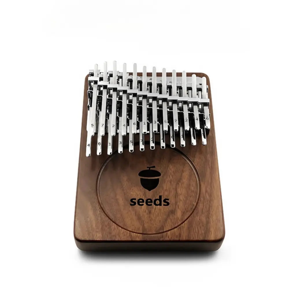 Fingers elegantly playing melodies on the Seeds kalimba with 24 keys.